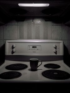 black ceramic mug on white electric stove