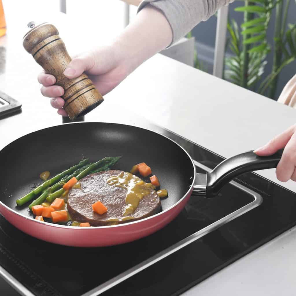 person holding black and red frying pan