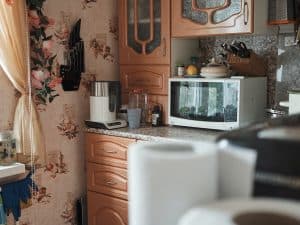 white microwave oven on brown wooden cabinet