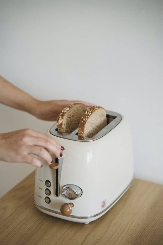 Close-up of Woman Putting Bread in a Toaster