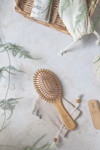 Wooden Hair Brush near a Woven Basket