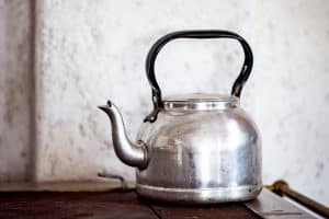 stainless steel kettle on brownHow to Clean a Kettle With Limescale wooden table